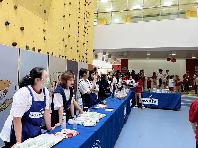 College Application Timeline: A Month-by-Month Guide 2 QISS students and staff collaborating at a school event, reflecting the community support available during the college application process