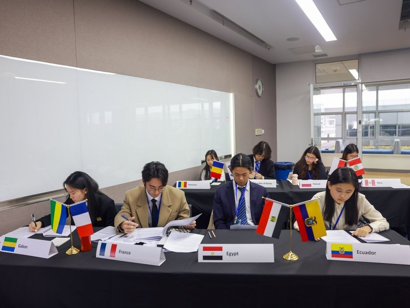 College Application Essays: How to Stand Out 2 High school students at a Model UN conference table with country flags, representing international student experiences that strengthen college essays