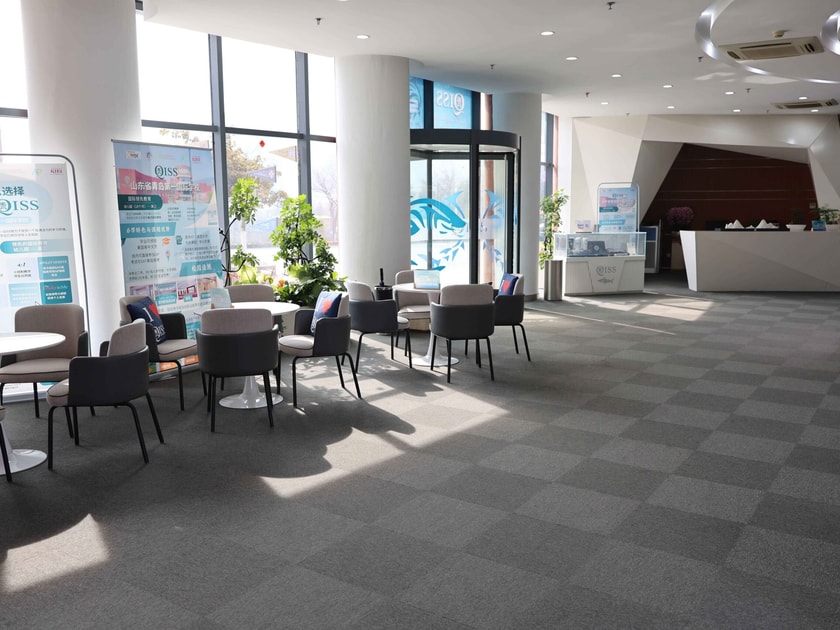 SAT Test Centers in Qingdao: Where to Register and Sit 2 Modern bilingual reception lobby at QISS Qingdao with Chinese and English signage, welcoming students preparing for the SAT