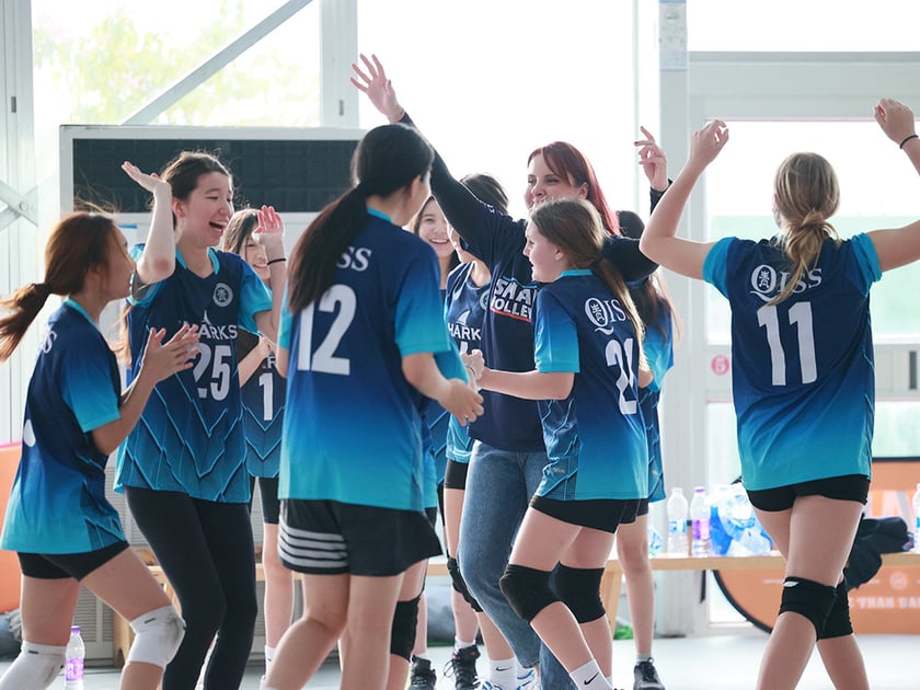Student Wellbeing in Schools: What Actually Works 3 A middle school girls' volleyball team celebrates together with raised arms and smiles in a bright modern gymnasium