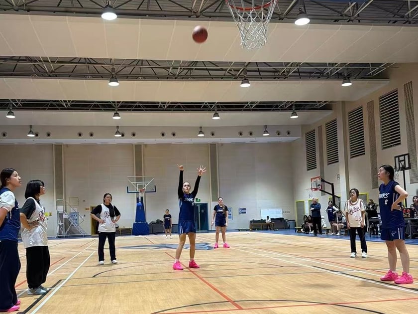School Athletics Programs: Sports for Every Student 3 Middle school students playing a basketball game in QISS's modern gymnasium during a school athletics event