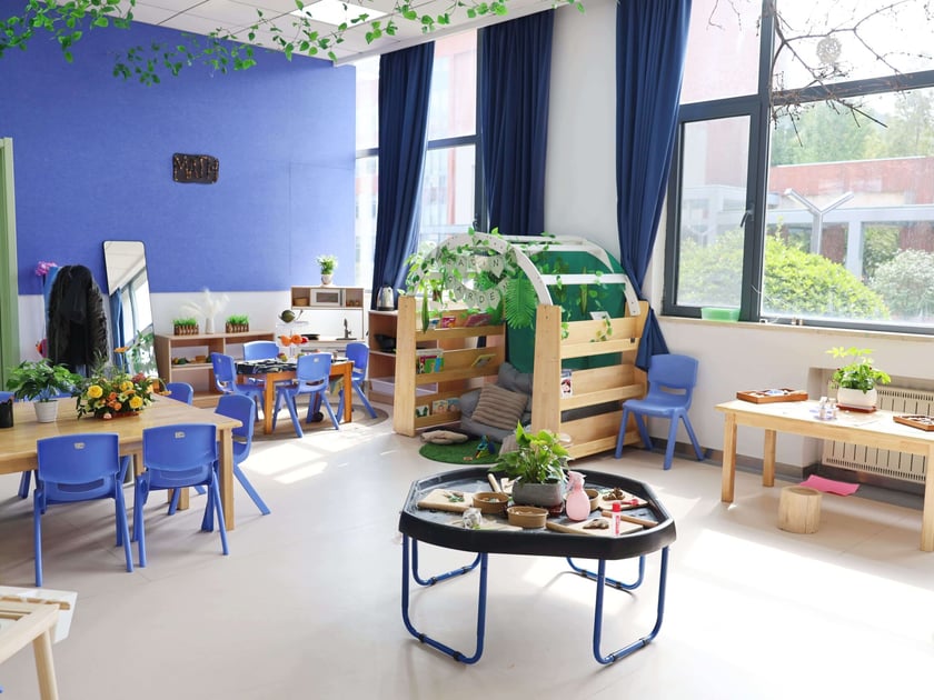 Vibrant early-childhood classroom with nature-based learning stations and collaborative furniture at an international school