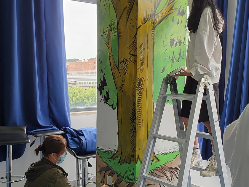 School Art Facilities: Studios, Stages, and What to Look For 1 Two students collaborating on a vibrant tree mural in a bright classroom, demonstrating school arts values