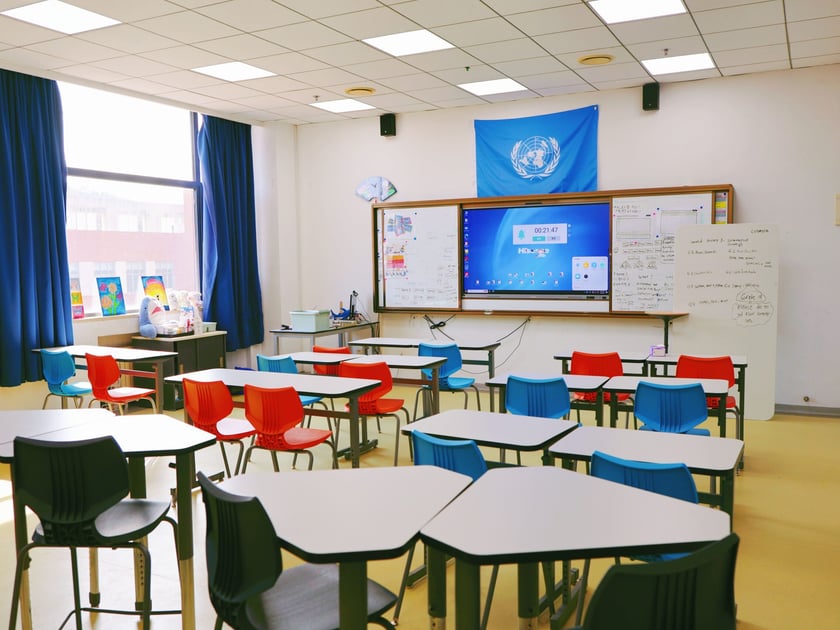 Screen Time and Students: What the Research Shows 3 Bright modern classroom with interactive display screen and collaborative seating for K-12 students