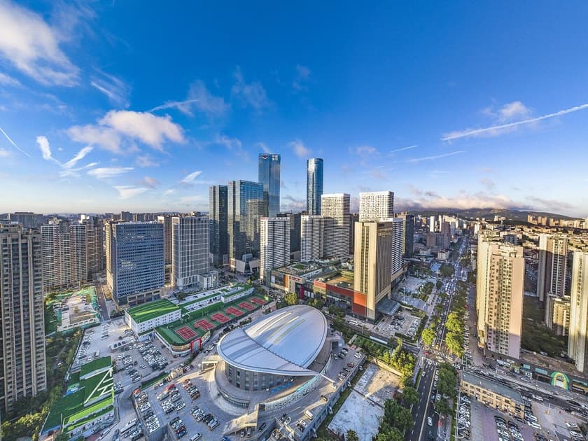 International Middle Schools in China: A Parent's Guide 2 Aerial cityscape of Qingdao with modern architecture, green spaces, and mountains in the distance