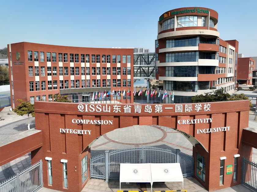 International Primary Schools in China: A Parent's Guide 1 QISS Qingdao international school campus exterior with global flags and school values signage