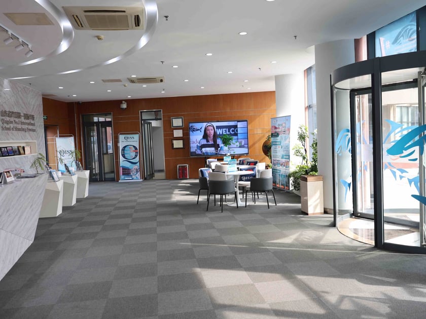 School Campus Safety: What Parents Should Know 3 Bright QISS school lobby with reception desk, digital welcome screen, and secure glass entrance doors