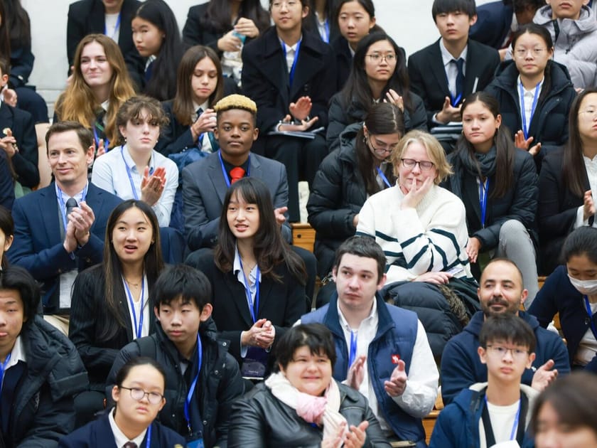 How to Build a University Shortlist That Fits You 1 Diverse QISS high school students and faculty applauding at a school assembly, reflecting community culture