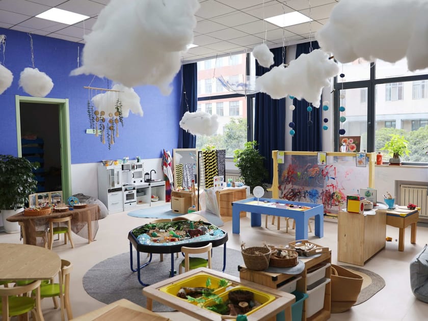 Raising a Reader: Building Lasting Reading Habits 2 Bright early-childhood classroom at QISS with learning stations, cloud decorations and natural wood furniture