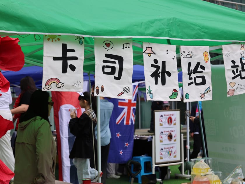 AP Chinese Language and Culture: A Guide for Students in China 1 Hand-decorated banners with large Chinese characters hang from a stall at the QISS International Day Festival