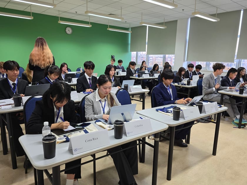Early Action vs Early Decision: What Students in China Should Know 2 High school students in blazers work on laptops at desks in a classroom during a Model UN conference