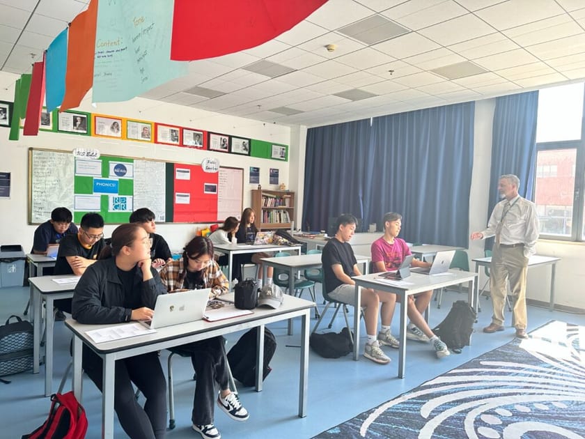 Free Digital SAT Practice: Official Resources for Students in China 1 High school students at QISS work on laptops at their desks while a teacher leads the class