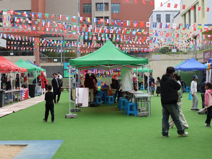 International Day at School: What Parents Should Know 1 Festival tents and strings of national flags fill the courtyard during the QISS International Day Festival