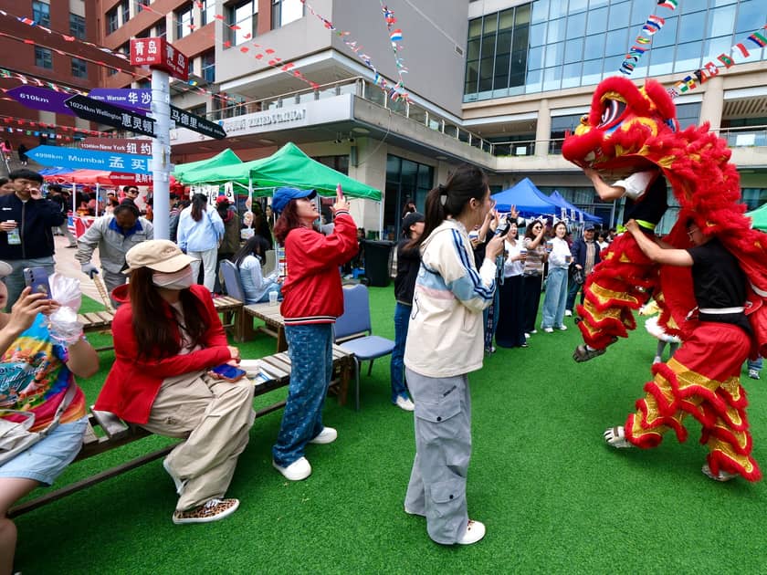 International Day at School: What Parents Should Know 4 A lion dance performs on the courtyard as families clap and take photos at the QISS International Day Festival