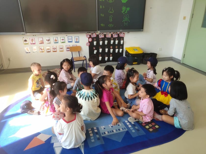 International Kindergartens in China: A Parent's Guide 1 Young children sit in a circle on a colorful mat in a QISS Early Childhood classroom